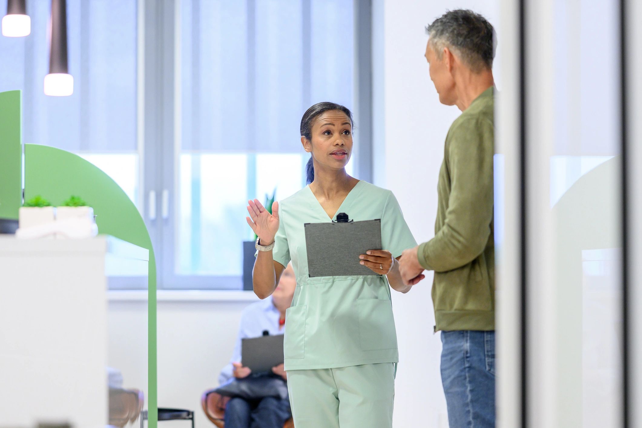 Nurse discussing health with older man in clinic